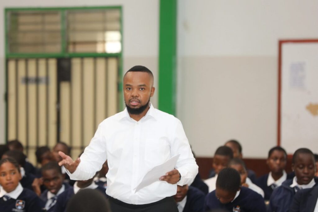 Presenter speaking to a hall of secondary school students