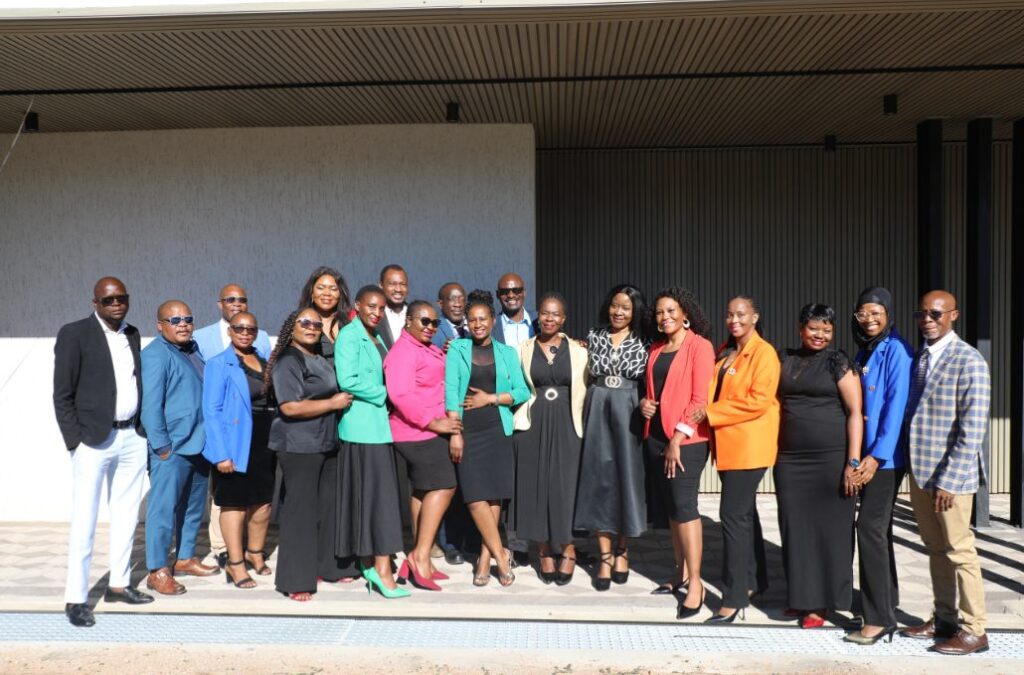 Group of about twenty people posing outside a building